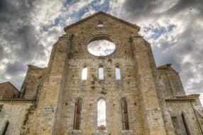 Beautiful San Galgano abbey, under the cloudy sky in Tuscany, Italy