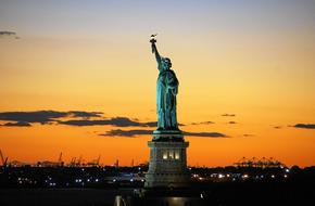 statue of liberty against the background of an opange sunset