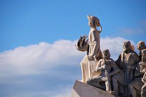 Monument with people in Lisbon at blue sky background with white clouds