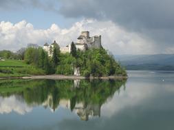 Beautiful Castle Niedzica among the plants on the shore in Poland