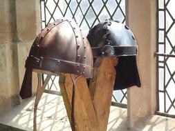 two medieval viking helmets against the backdrop of a castle window