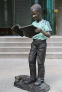 Statue of the boy with book in green shirt