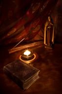 candle and sculpture of saint mary on a table in the dark