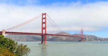 Golden Gate Bridge in the haze against the backdrop of mountains in San Francisco