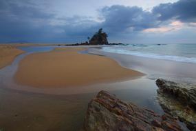 Seascape with the rocks on the sandy shore