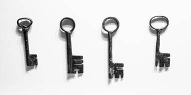 Four old, metal keys, at white background, with shadows