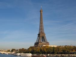 Beautiful Eiffel Tower, among the colorful trees, on the shore in Paris, France