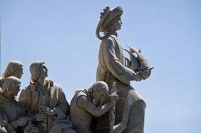 sculpture of people against the blue sky