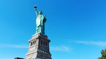 photo of the American Statue of Liberty against the blue sky