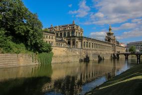 old palace is reflected in the river on a sunny day