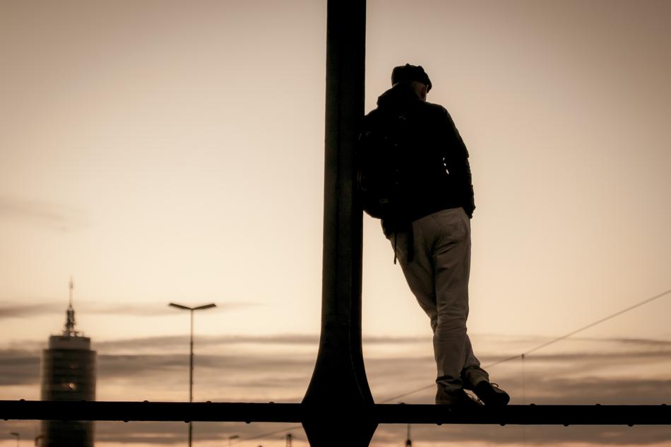 monochrome photo of a man at the pillar