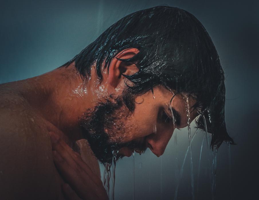 male model under the shower in profile
