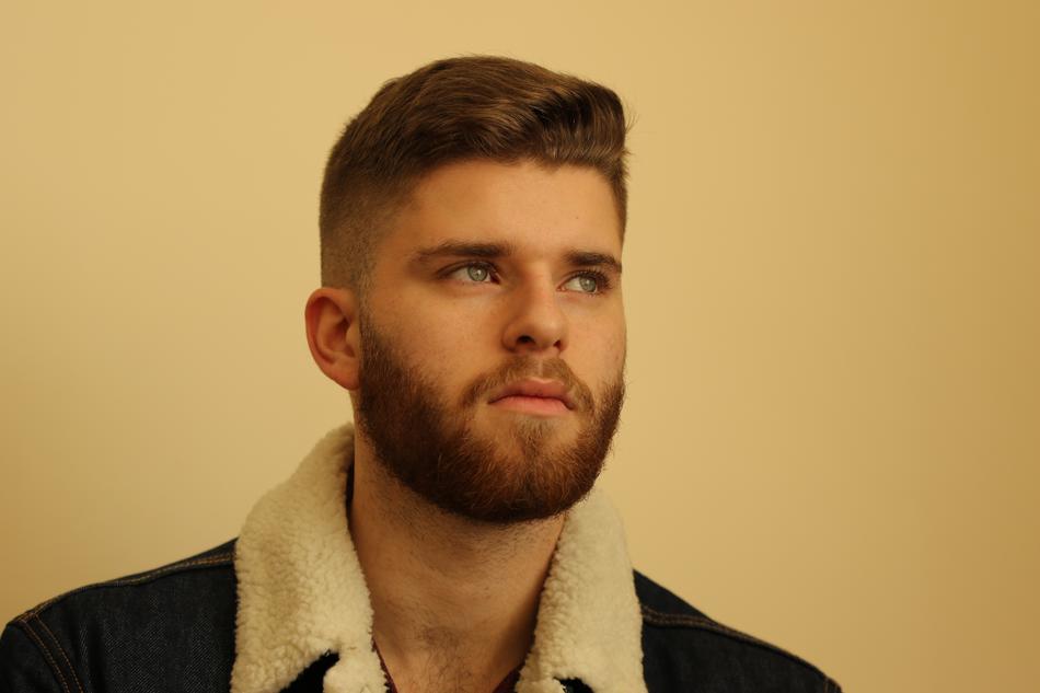 portrait of a fashionable guy near the wall