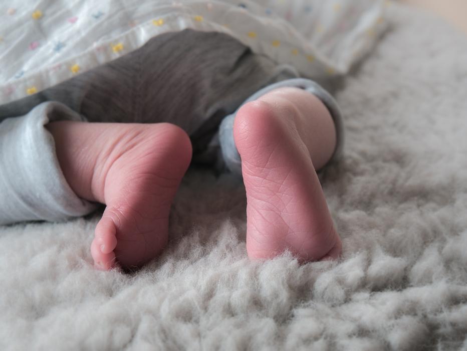 feet of a newborn under the covers