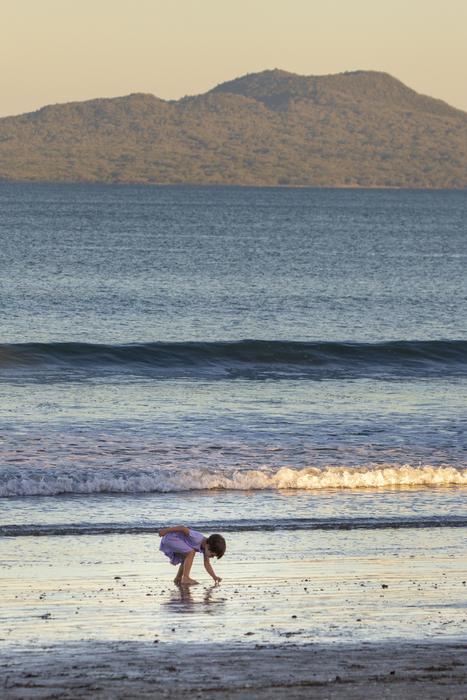 distant view of a child on wet sand on the coast