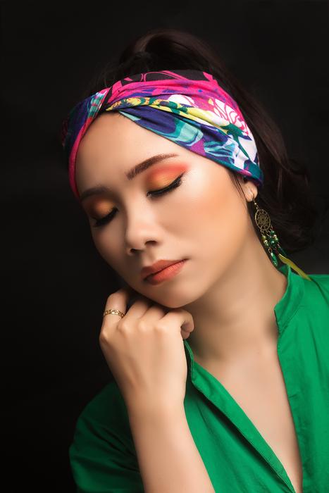 photo of a girl with makeup and a multi-colored bandage on her head