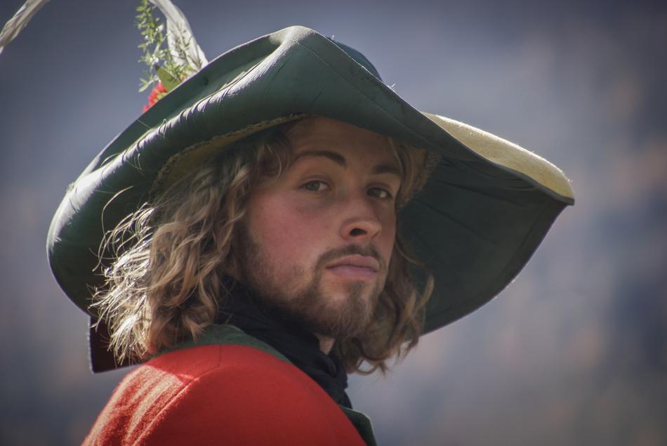 Portrait of the bearded, tenacious knight in the hat, at blurred background