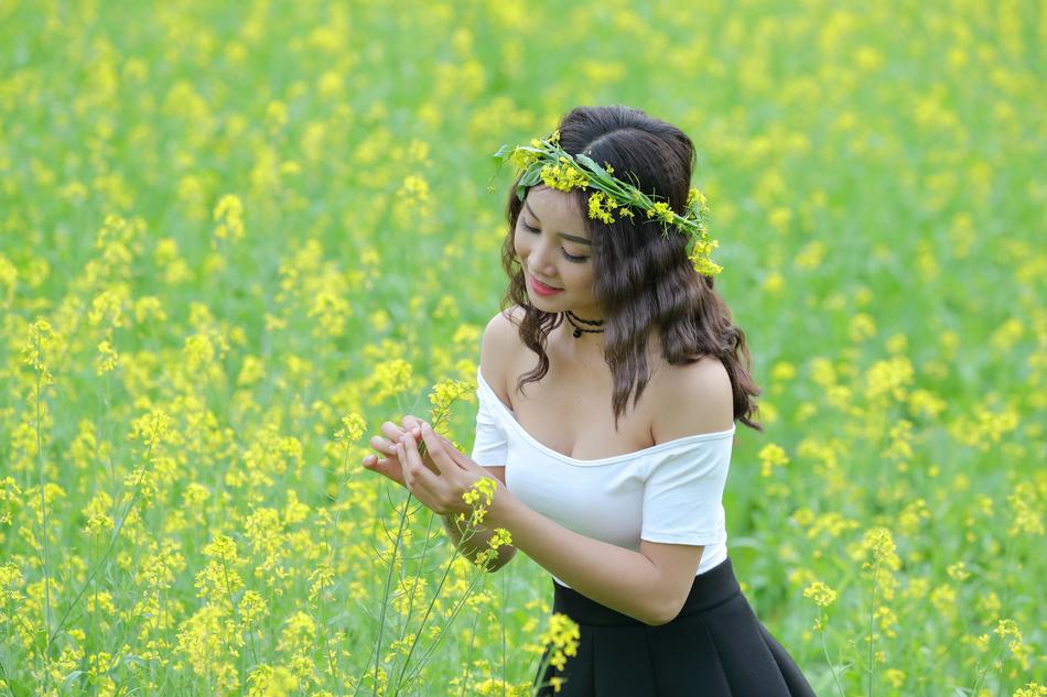 Smiling girl among the yellow flowers