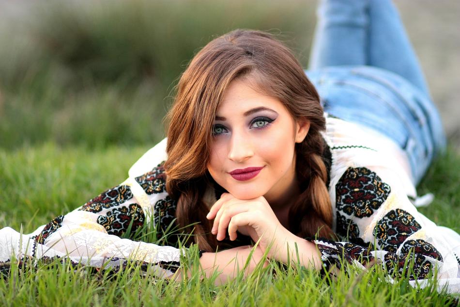 attractive girl with pigtails lies on the grass