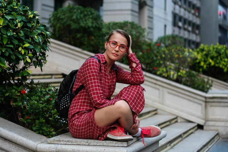 photo of a student in a burgundy plaid suit sitting on the steps