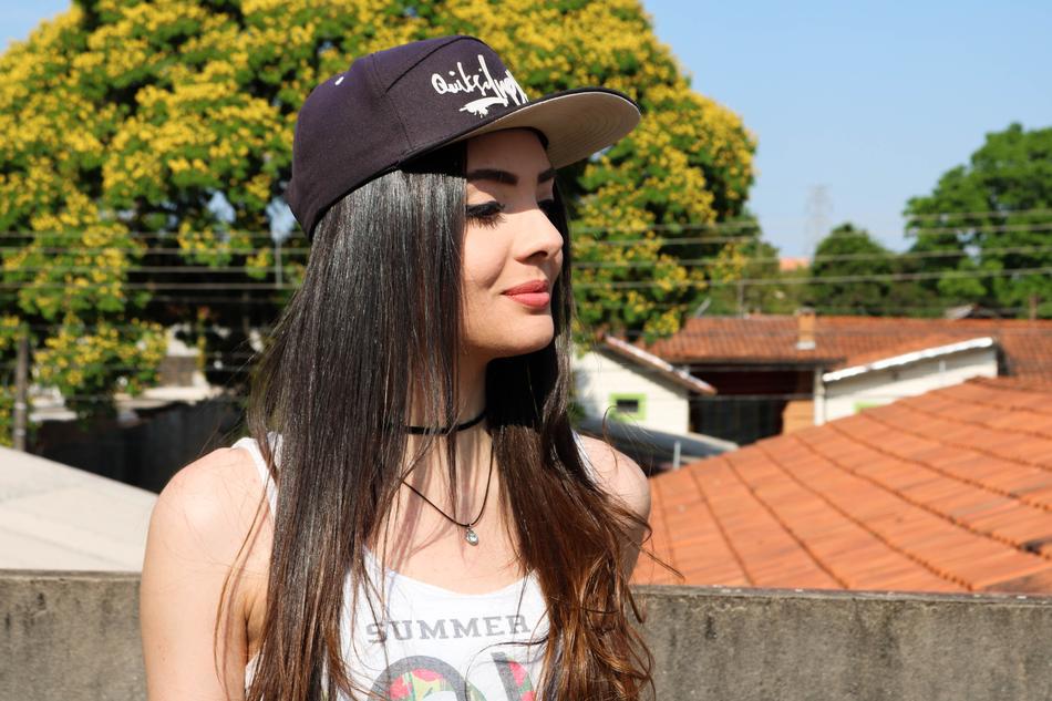 Portrait of the smiling girl, in black and white cap, on the roof, among the green and yellow trees