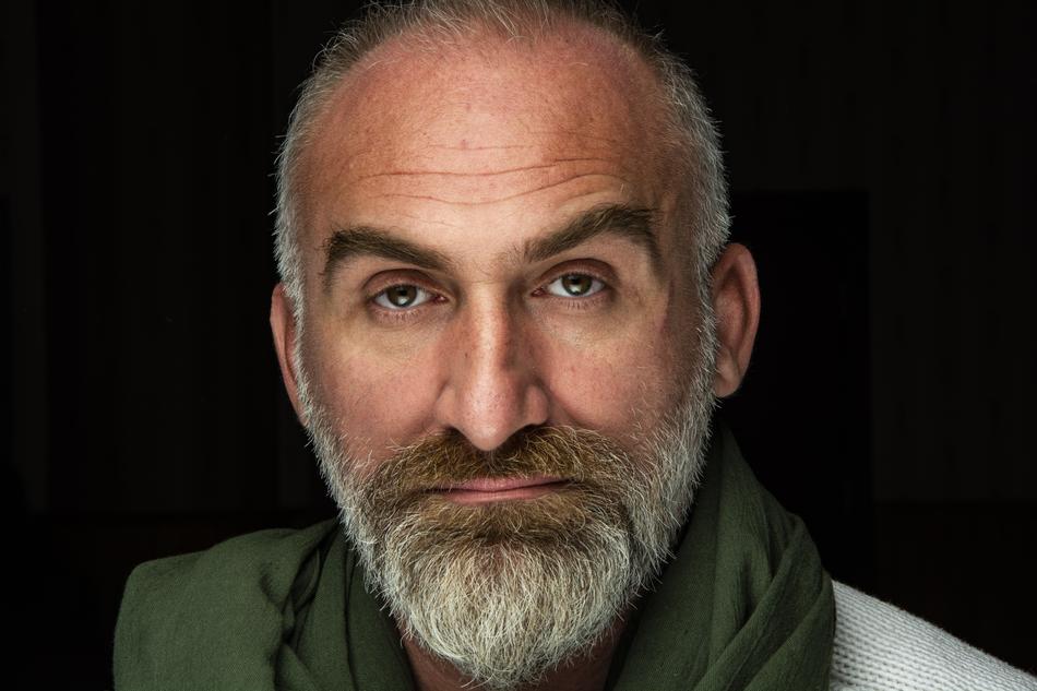Portrait of the artist with the beard, moustache and green scarf, at black background
