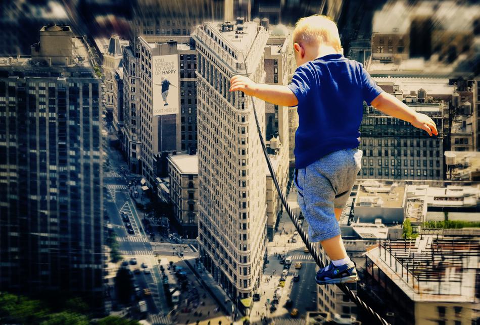 child walks on a tightrope over a large city