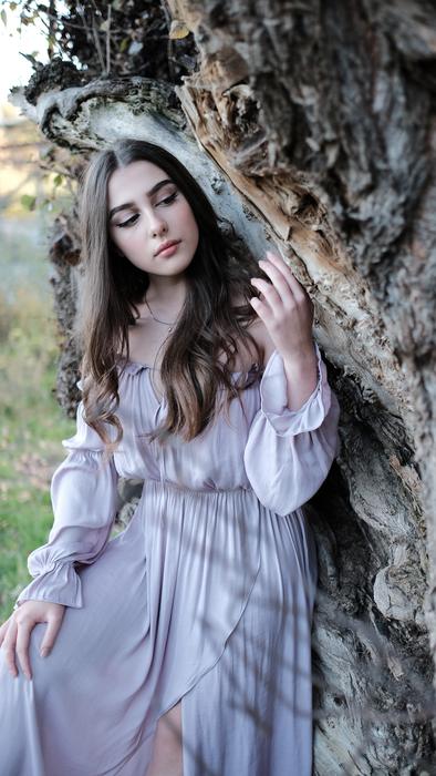 girl in vintage dress by the old tree