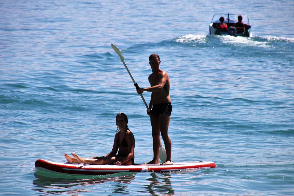 couple swims on a board on the lake