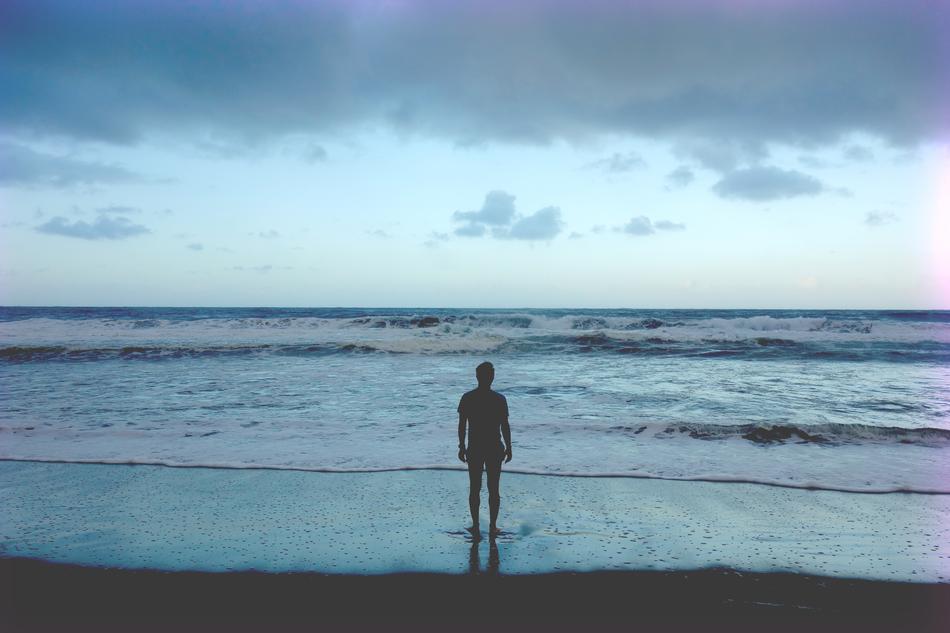man on the ocean surf at dusk