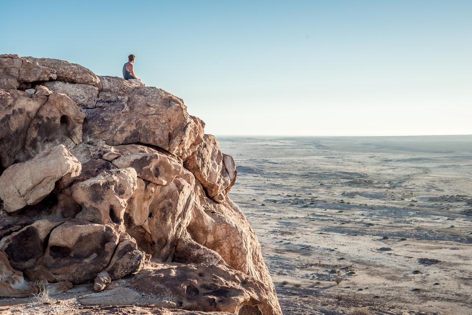 man on a rocky cliff on the coast