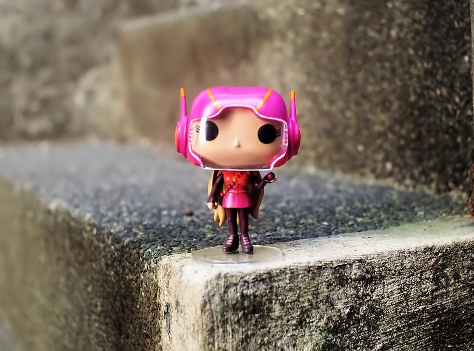 little doll in a pink helmet on the step