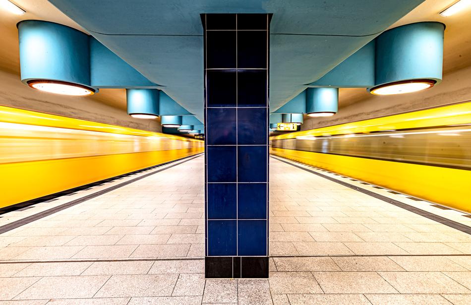 Colorful metro of the Nauerner Square, with the pillars, lights and trains in motion, in Berlin, Germany