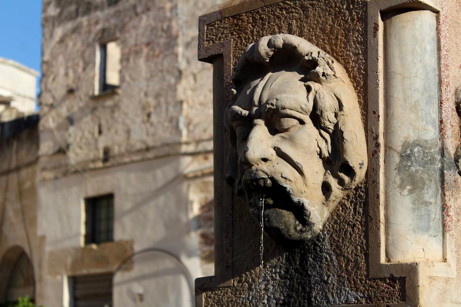Beautiful sculpture of the man, near the buildings in Italy