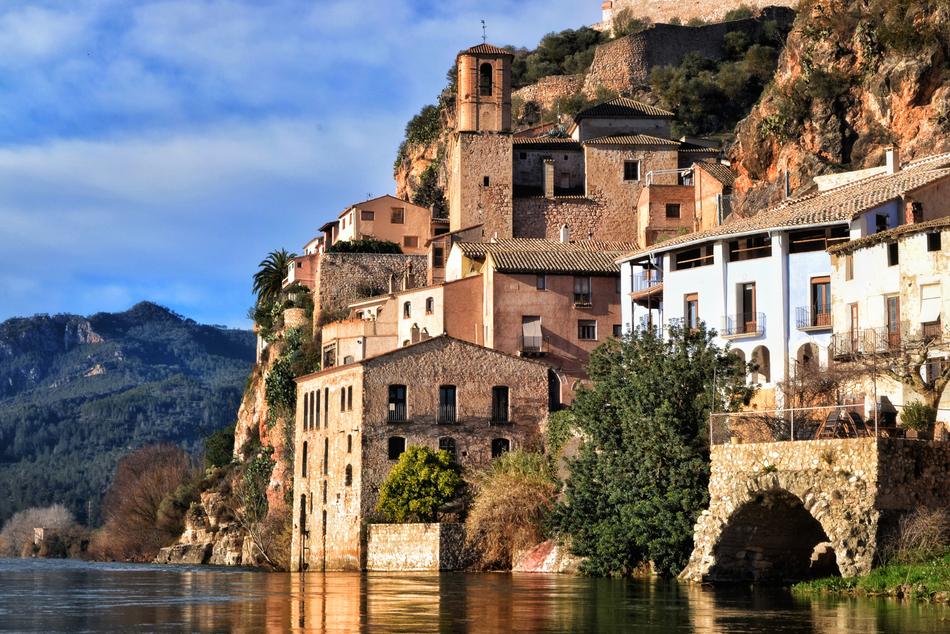 Beautiful landscape of the colorful town on the rocky shore of the river in Spain