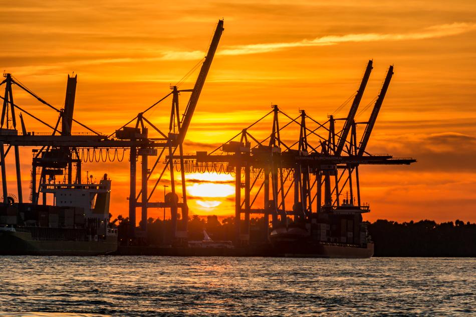 Silhouette of the port of Hamburg, on the coast of Elbe, at beautiful and colorful, gradient sunset, in Germany