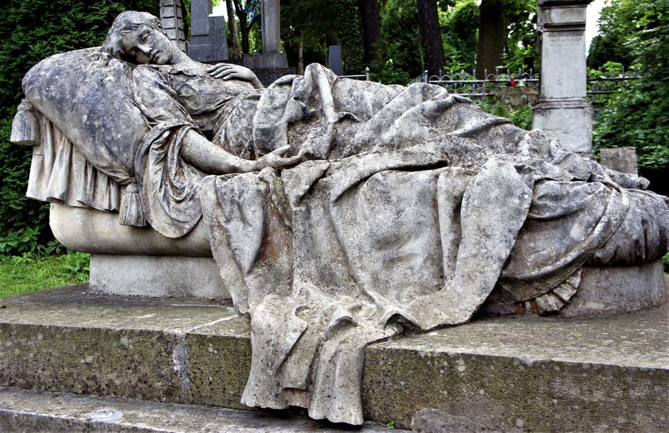 Beautiful, old grave monument, among the green trees, in Lviv, Ukraine