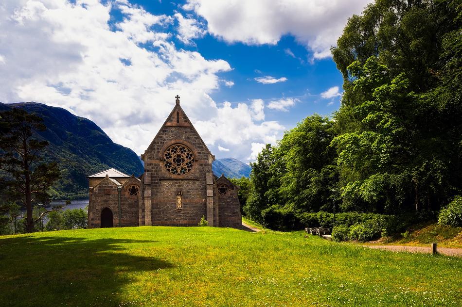 Beautiful church, among the green and yellow plants on the mountains in Scotland