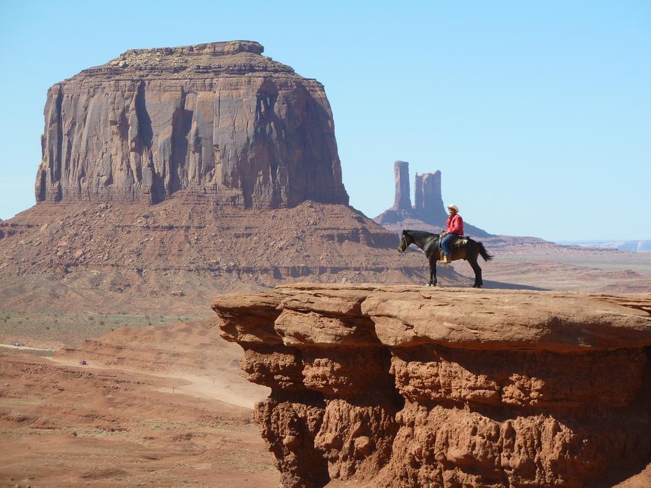 Cowboy on the horse, on the cliff in the beautiful Monument Valley with the desert in USA