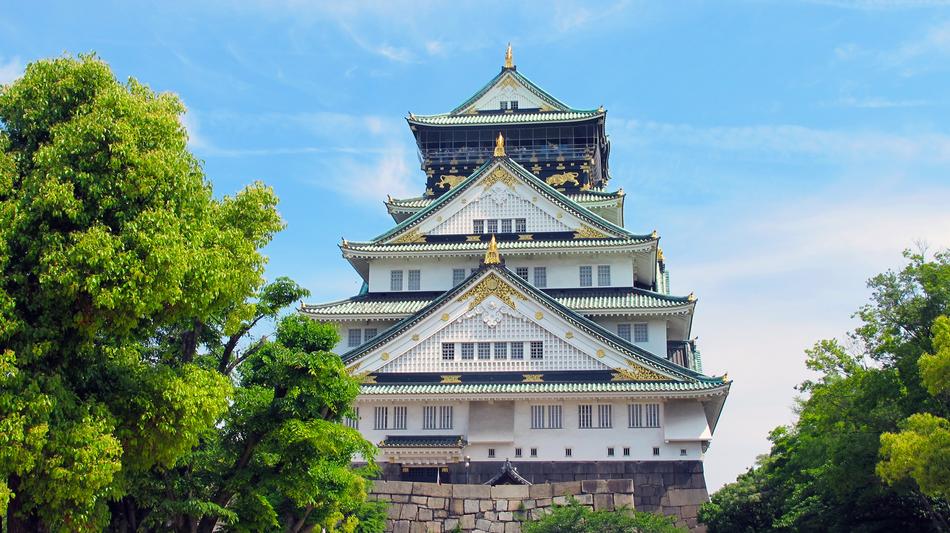 osaka castle behind green trees