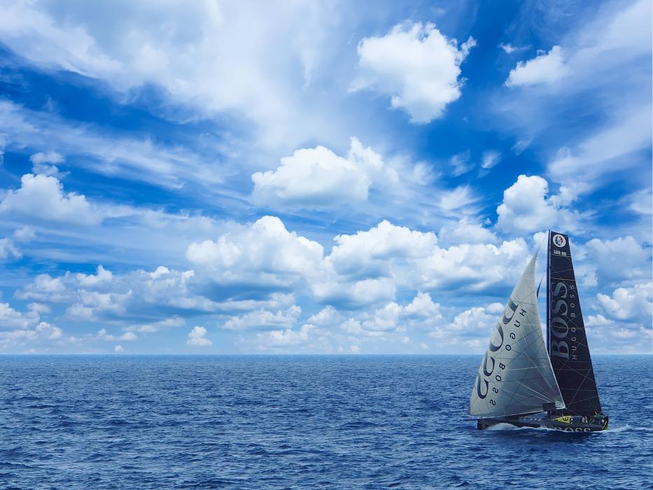 Yacht on the race, in the blue water, with ripple , in Valletta, Malta, under the blue sky with white clouds