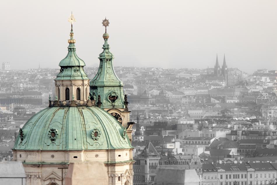 green roof on the church against the backdrop of the cityscape in prague