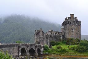 Beautiful castle, on the green hill in Scotland, in the clouds