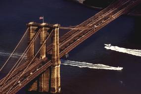 photo of speed boats under the Brooklyn Bridge