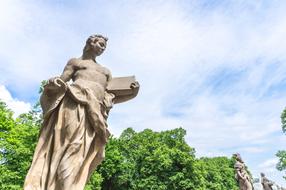statue with a book in a park in Warsaw