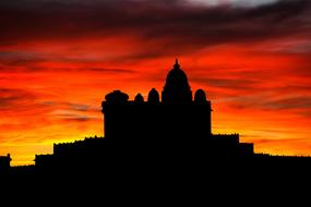 silhouette of an asian temple against the background of a yellow-orange sunset