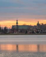 Beautiful landscape with the Benedictines monastery on the shore of the pond, in Poland, at colorful, gradient sunset