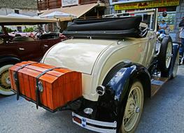 cream and black colored Antique Car on exhibition