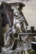 sculpture of a woman on a grave in a cemetery