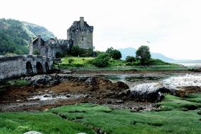 Beautiful landscape of the Eilean Donan Castle, near the water, among the green plants, in Scotland, UK